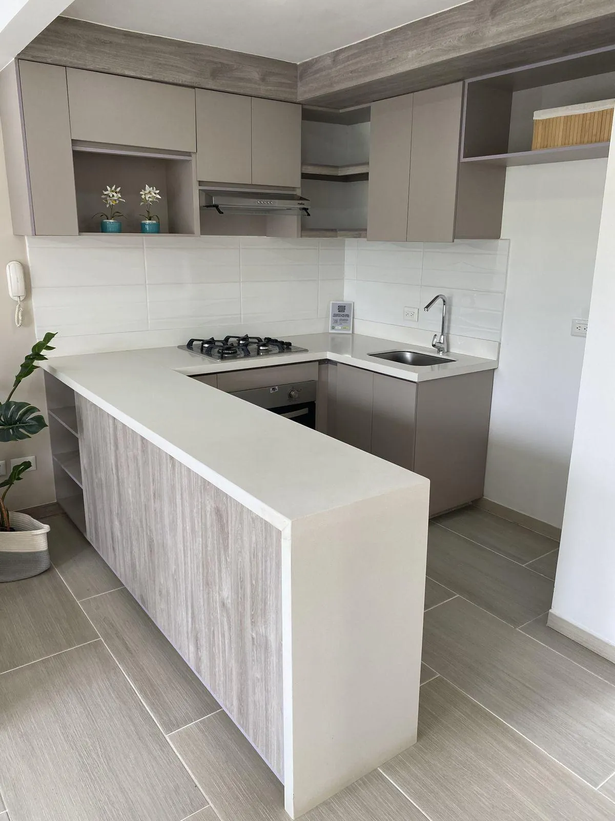 Cocina en L con mesón blanco y cascada, trabajo realizado