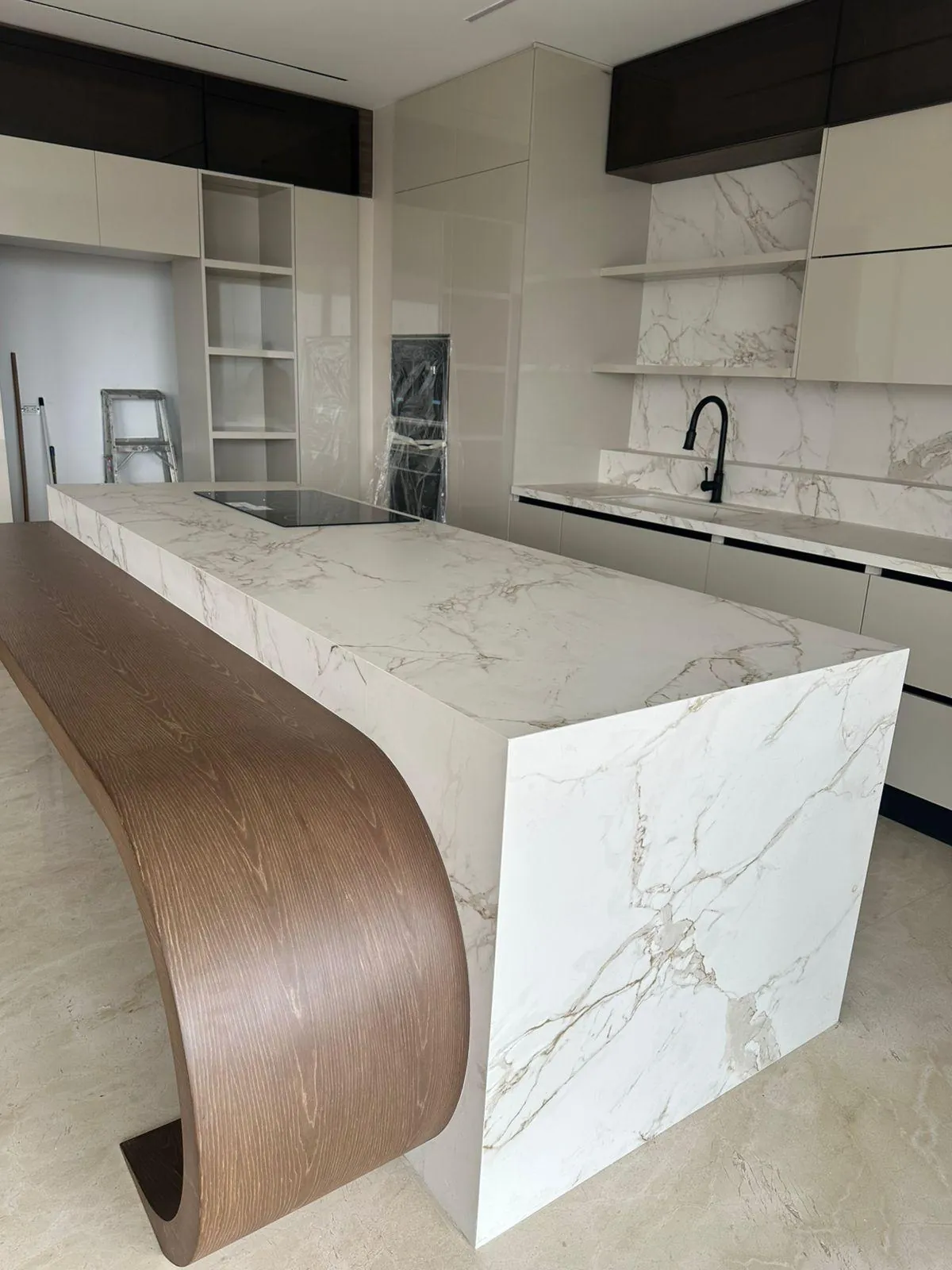 Isla de cocina con caída en cascada y barra curva en madera, trabajo realizado en Cali