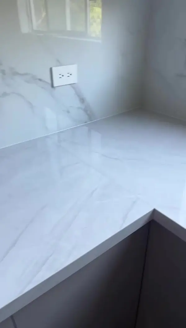 Mesón en L blanco con vetas suaves